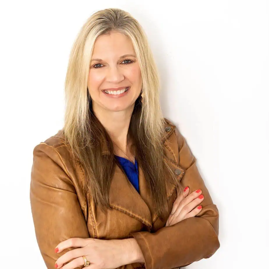 Headshot of Rachel  Wojo  Wojnarowski, a smiling woman with long blonde hair, red fingernails, wearing a blue shirt and brown leather jacket, arms crossed against a white background. She is a podcast guest on GPS Hope, sharing her journey through child loss, miscarriage, and prayer. Rachel, author of  Desperate Prayers  and the  Three-Word Prayers  approach, encourages grieving parents by showing how prayer can sustain faith in life's darkest valleys. GPS Hope   Grieving Parents Sharing HOPE.