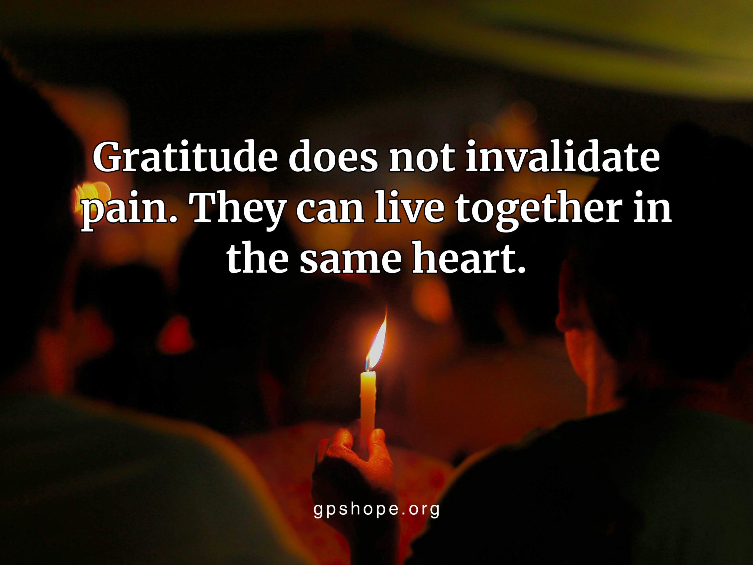 A dark, low-light scene shows a small yellow candle glowing in a person’s hand during a vigil, with blurred figures gathered in the background. The overlaid quote reads, “Gratitude does not invalidate pain. They can live together in the same heart,” with gpshope.org at the bottom. This image reflects grief, child loss, grieving parents, and pareavor support during moments of remembrance. GPS Hope - Grieving Parents Sharing HOPE